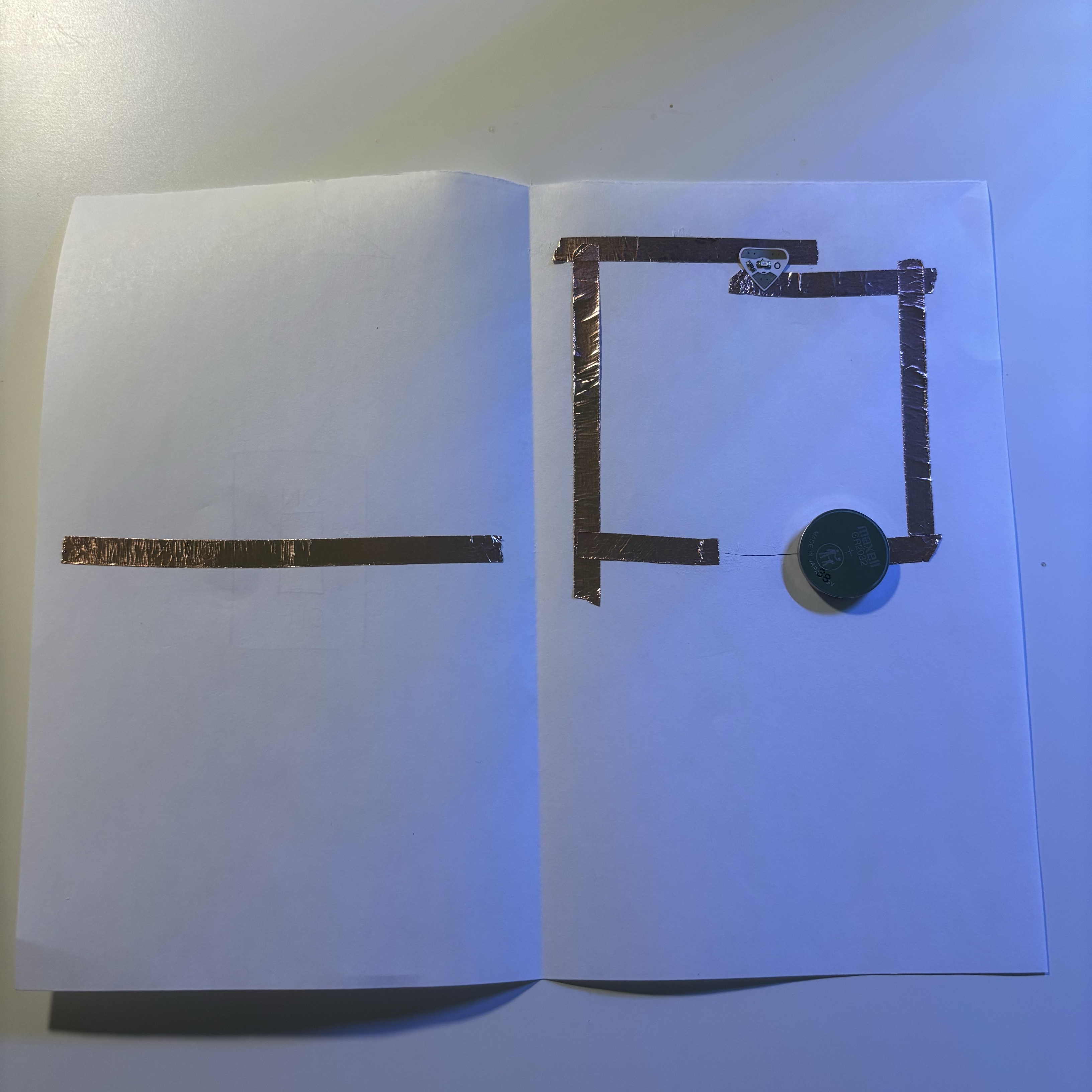 Here is the circuit for this simple switching device. I started by folding the paper in half and building a disconnected circuit. Put a piece of copper tape where the switch would be. This way, when the user presses the switch, this section of copper tape will link the circuit and make the LED light up.