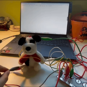 In this attempt, I used a plush toy as the trigger, attaching wires to different parts of it. I programmed a simple design in P5.js so that when the circuit is completed at a specific part, the corresponding word for that body part appears on the screen.